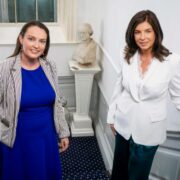 Woman in blue dress and woman in white coat.