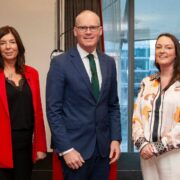 Two women and a man at an event.