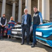 Three men and a woman with electric cars.
