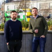 Two men with a bus in the background.