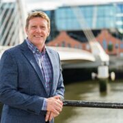 Man standing beside Liffey in Dublin.