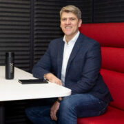 Man sitting on red seat.