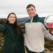 Man and woman on a hill near a lake.