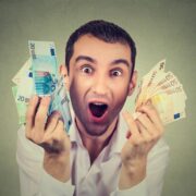 Young worker holding up cash.