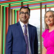 Man in blue suit beside woman in pink dress.