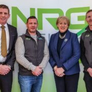 Three men and a woman in a blue blazer.