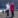 Woman in white coat beside woman in red coat on a beach in Ireland.