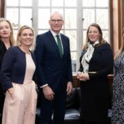 Four women and a man in a suit.