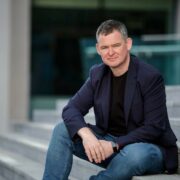 Man in navy sports jacket.