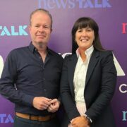 Man in dark shirt beside woman in black jacket.