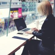 Woman working at window above a crowded city street.