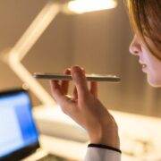Female doctor dictating notes into a smartphone.