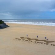 People draw words Wild Atlantic Way on a beach in Ireland.