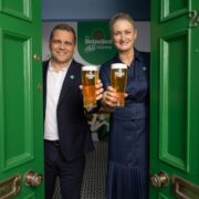 Man and woman holding pints of beer.