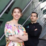 Woman in floral blouse and man in dark coloured hoodie.