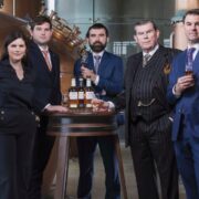 Four men and a woman in a whiskey distillery.