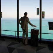Man in airport viewing azure sea.
