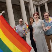 Two men and two women in Dublin with pride flags.