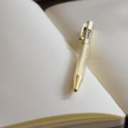 Gold pen on an open notebook.