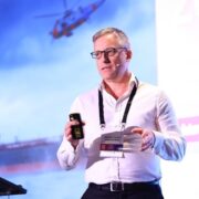 Man in white shirt presenting on stage.