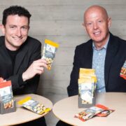 Two men holding cheese products.