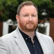 Bearded man in grey jacket.