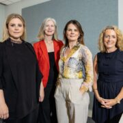 Four well-dressed women at an event.