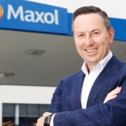 Man in blue jacket standing in front of a Maxol forecourt.
