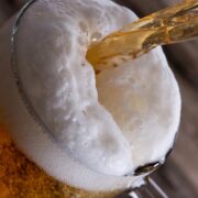 A pint of beer being pulled at a bar.