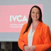 Woman in orange blazer.