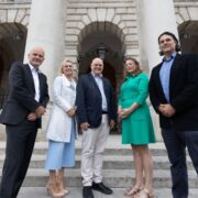 Three men and two women on the steps at Trinity College Dublin.