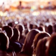 Large crowd of people watching concert or sport event.
