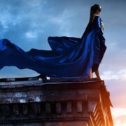 Woman in blue cape on a roof.