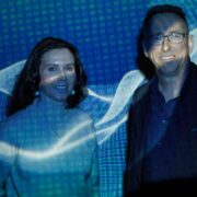 Man and woman with digital code projected.