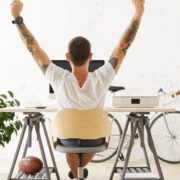 Man in white t-shirt working at desk.
