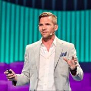 Man in grey jacket on stage.