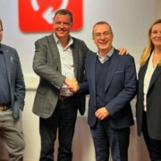 Three men and a woman in business attire.