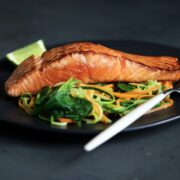 A salmon darn on a plate of vegetables.