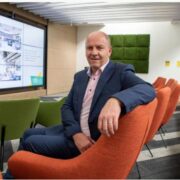 Man sitting in an orange chair.