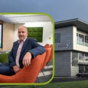 man in orange chair inset on image of exterior of a Fexco building.