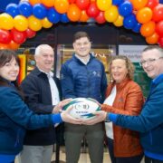 Group of people holding a rugby ball.