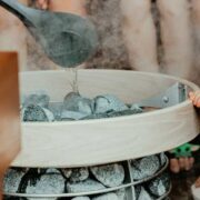 People gathered around stones in a sauna.