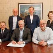 Five men and one woman at a table.