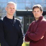 Two men in front of a building.