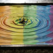 Pride flag reflected on a splash of water.