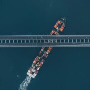 Container ship passing beneath a bridge.