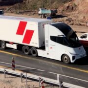 white and red electric truck on a motorway in Europe.