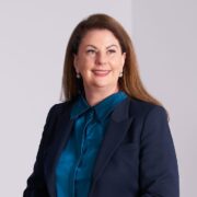 Brown haired woman in navy business suit.