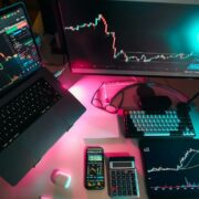 Investors' desk with multiple screens and devices.