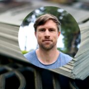 Man inset on picture of a stack of newspapers.